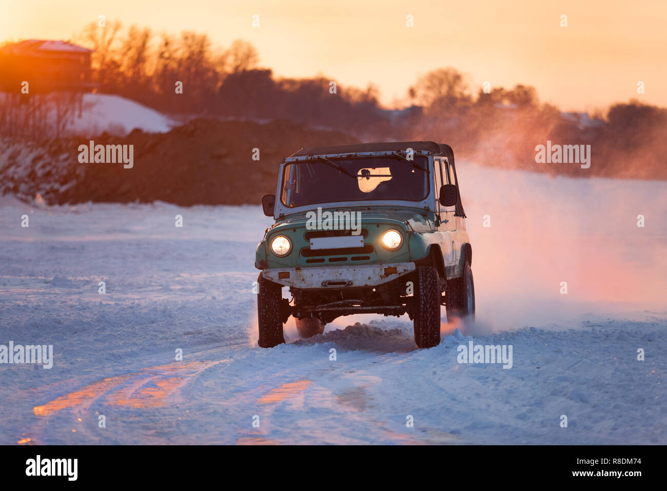 Russian UAZ 469 moving on ice of a frosn river at sunset Stock Photo