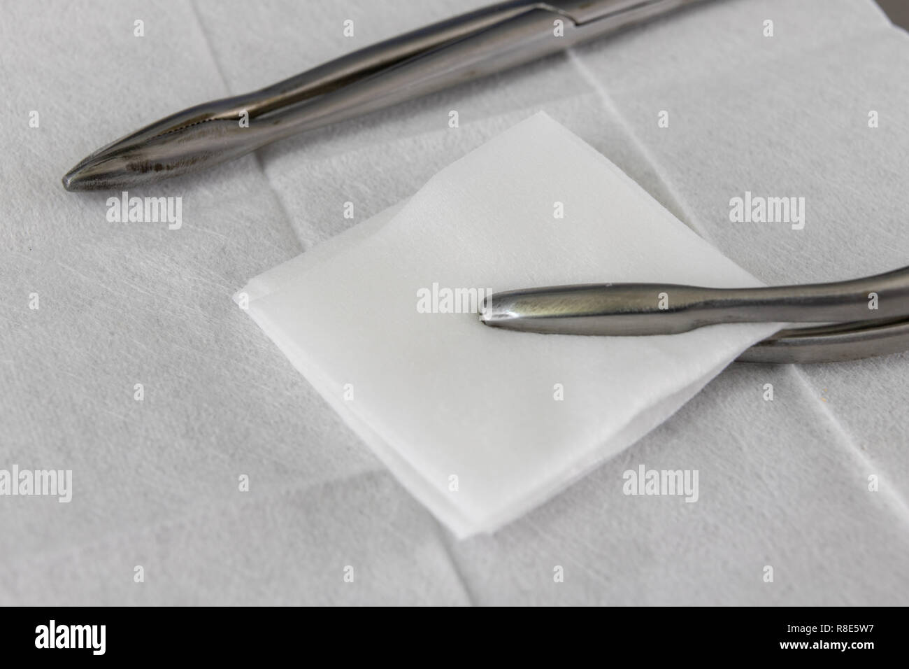 Sterile swab, pliers and a medical syringe on a hospital table