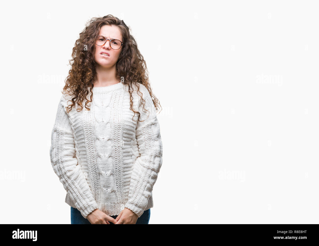 Beautiful brunette curly hair young girl wearing winter sweater over isolated background skeptic and nervous, frowning upset because of problem. Negat Stock Photo