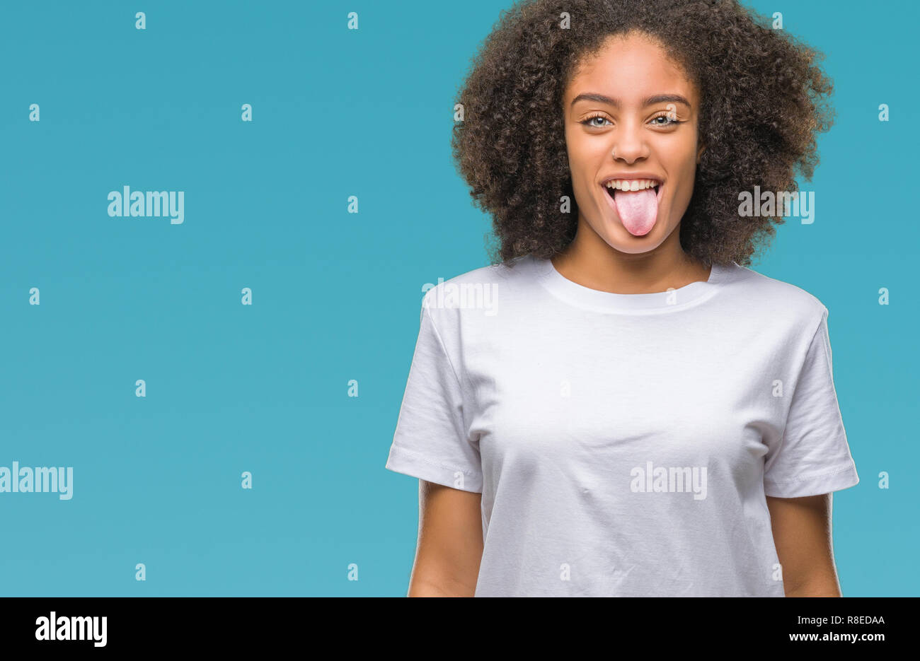 Young afro american woman over isolated background sticking tongue out ...