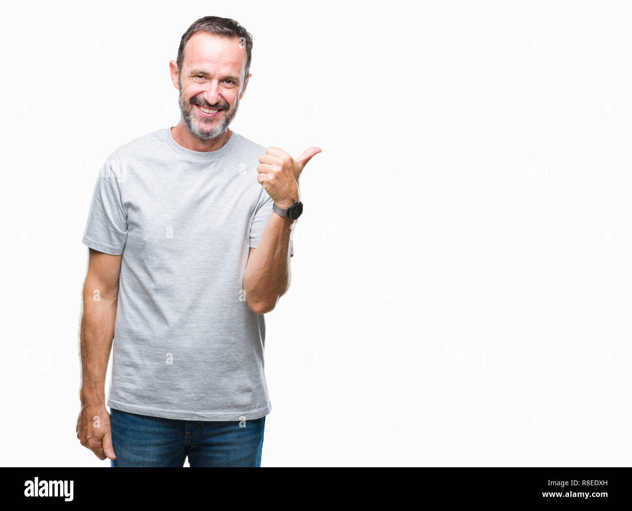 Middle age senior hoary man over isolated background smiling with happy face looking and pointing to the side with thumb up. Stock Photo