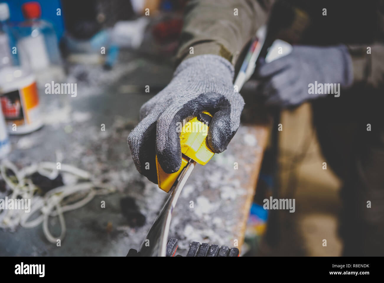 Male worker repairing Stone, edge sharpening in ski service