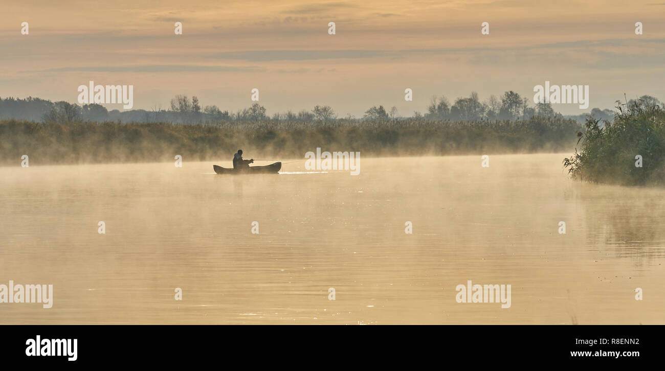 morning fog over the river, silhouette of a fisherman on a boat Stock ...