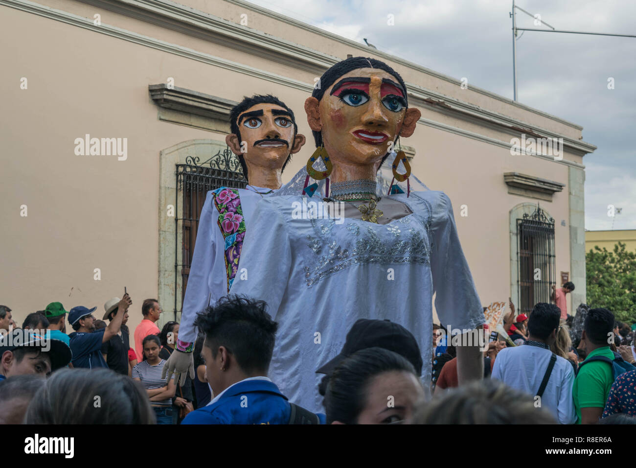 Giant male and female wedding puppets mimicking a bride and groom, on