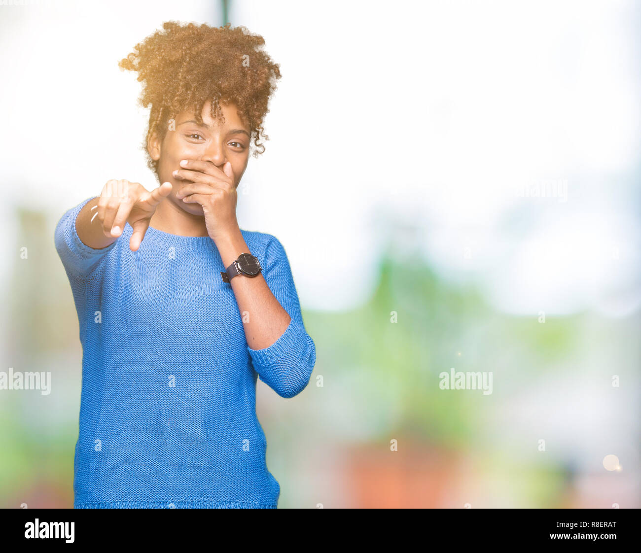 Beautiful young african american woman over isolated background Laughing of you, pointing to the camera with finger hand over mouth, shame expression Stock Photo