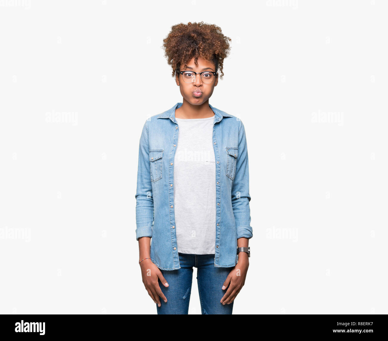 Beautiful young african american woman wearing glasses over isolated background puffing cheeks with funny face. Mouth inflated with air, crazy express Stock Photo