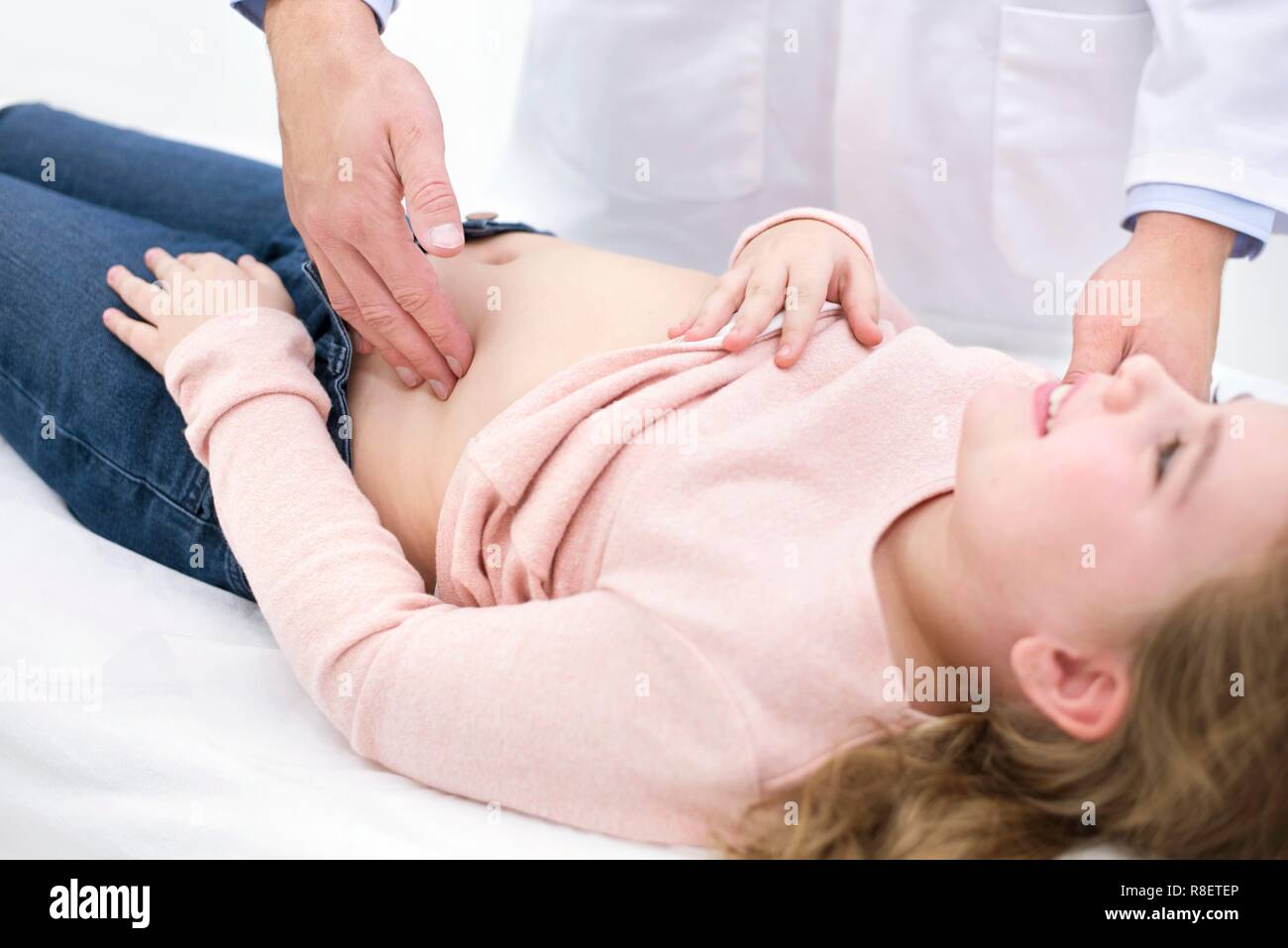 Doctor examining girl's abdomen Stock Photo