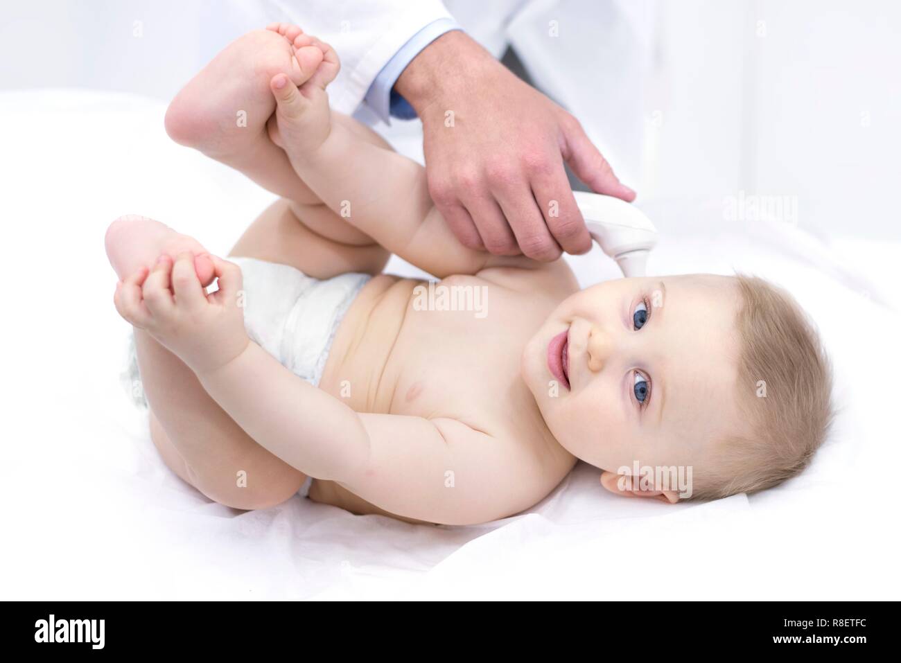 Doctor taking baby's temperature using digital thermometer. Stock Photo