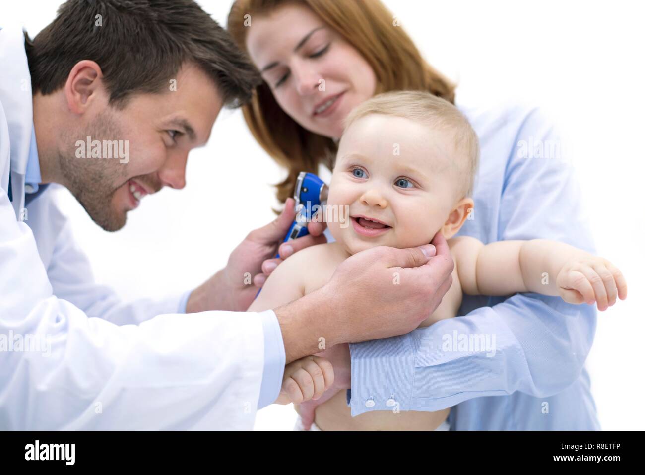 Doctor examining baby boy's ear with otoscope. Stock Photo