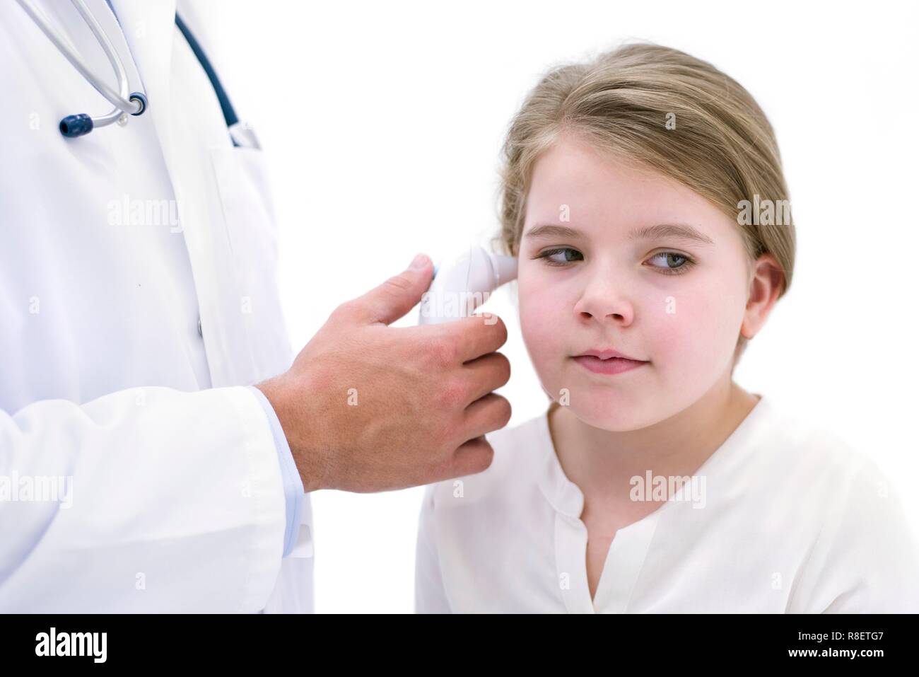 Doctor taking girl's temperature using digital thermometer Stock Photo
