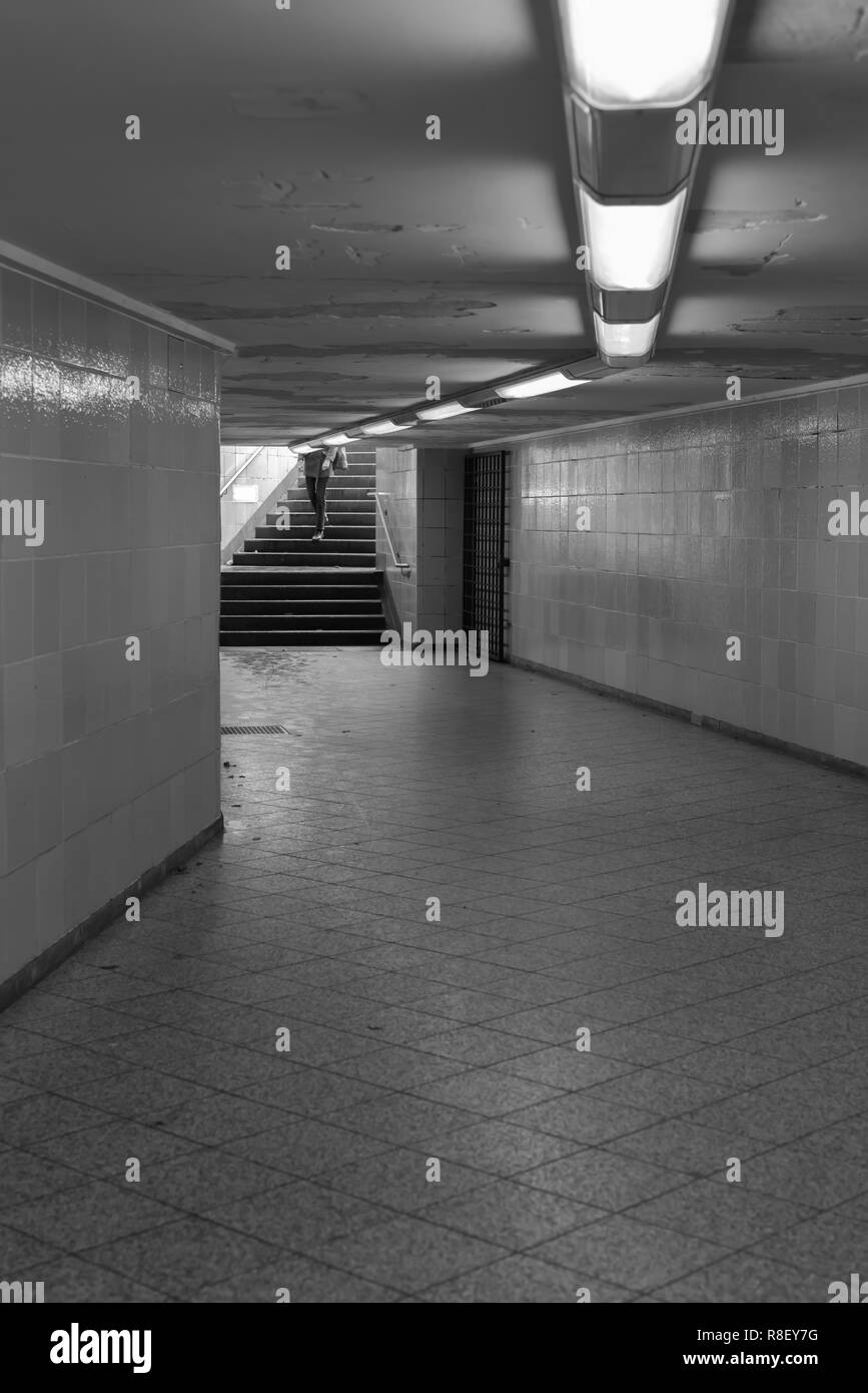 A person goes down the stairs into the underground Stock Photo