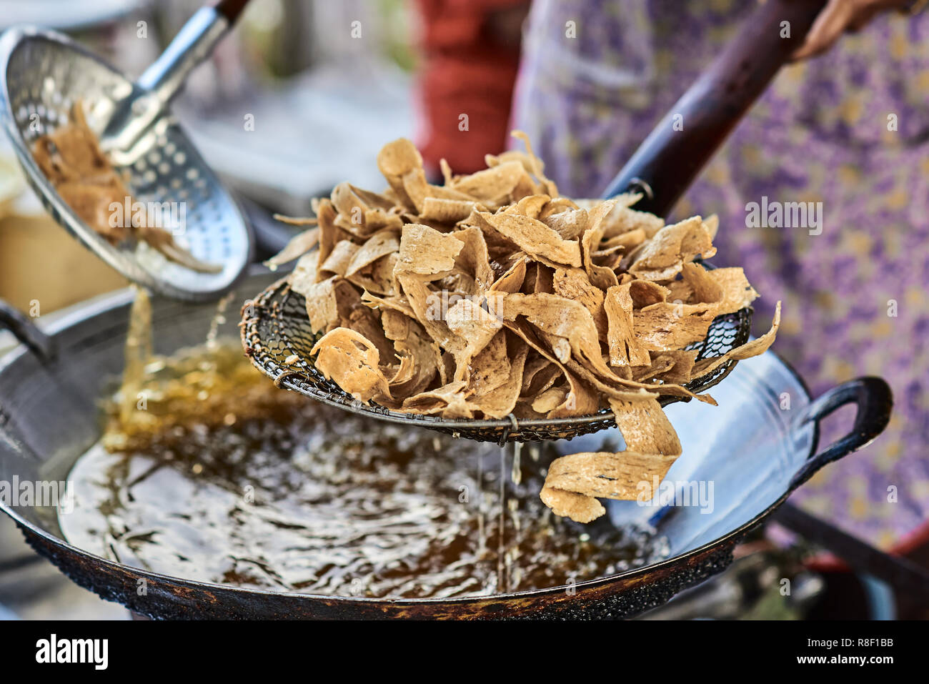 Cooking deep fried chips in boil yellow oil in big metal pan