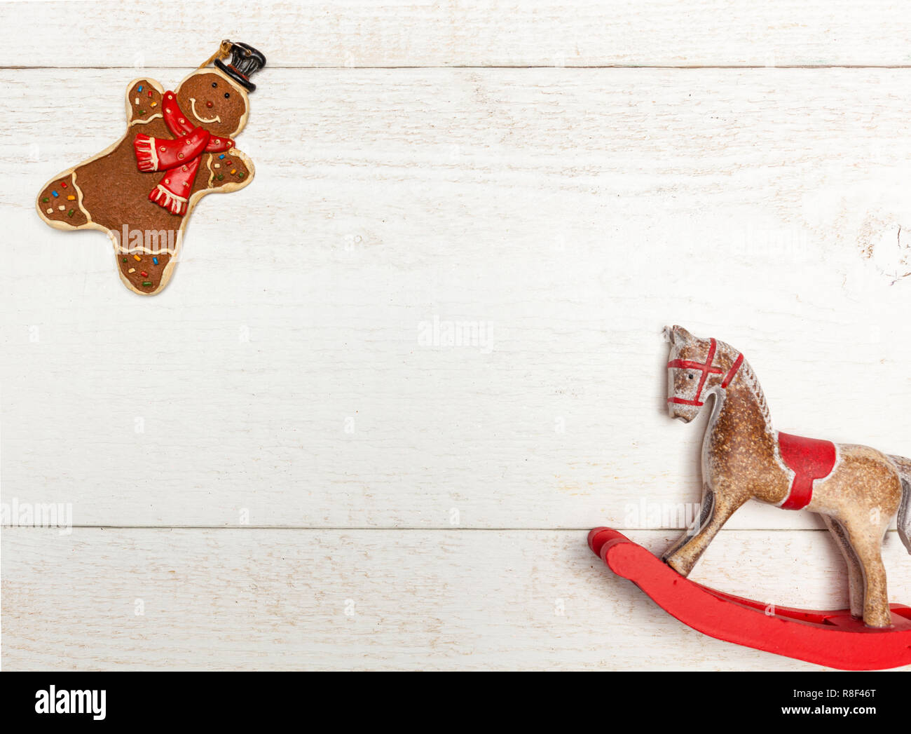Christmas frame with gingerbread man and rocking horse on white wooden background with copy space. Stock Photo