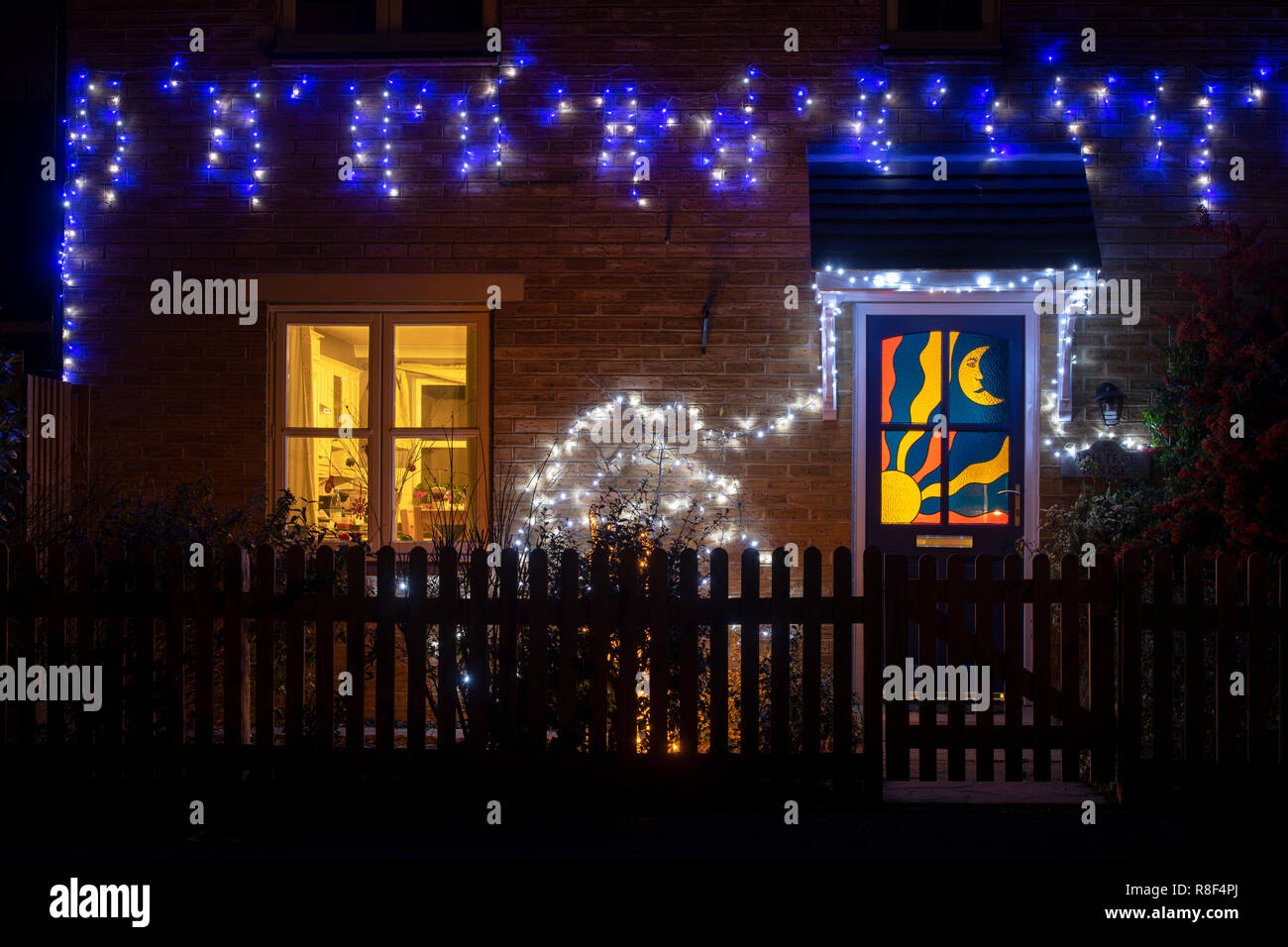 Sun and moon stained glass door and christmas lights on a house in Bloxham. Bloxham, Oxfordshire, England Stock Photo