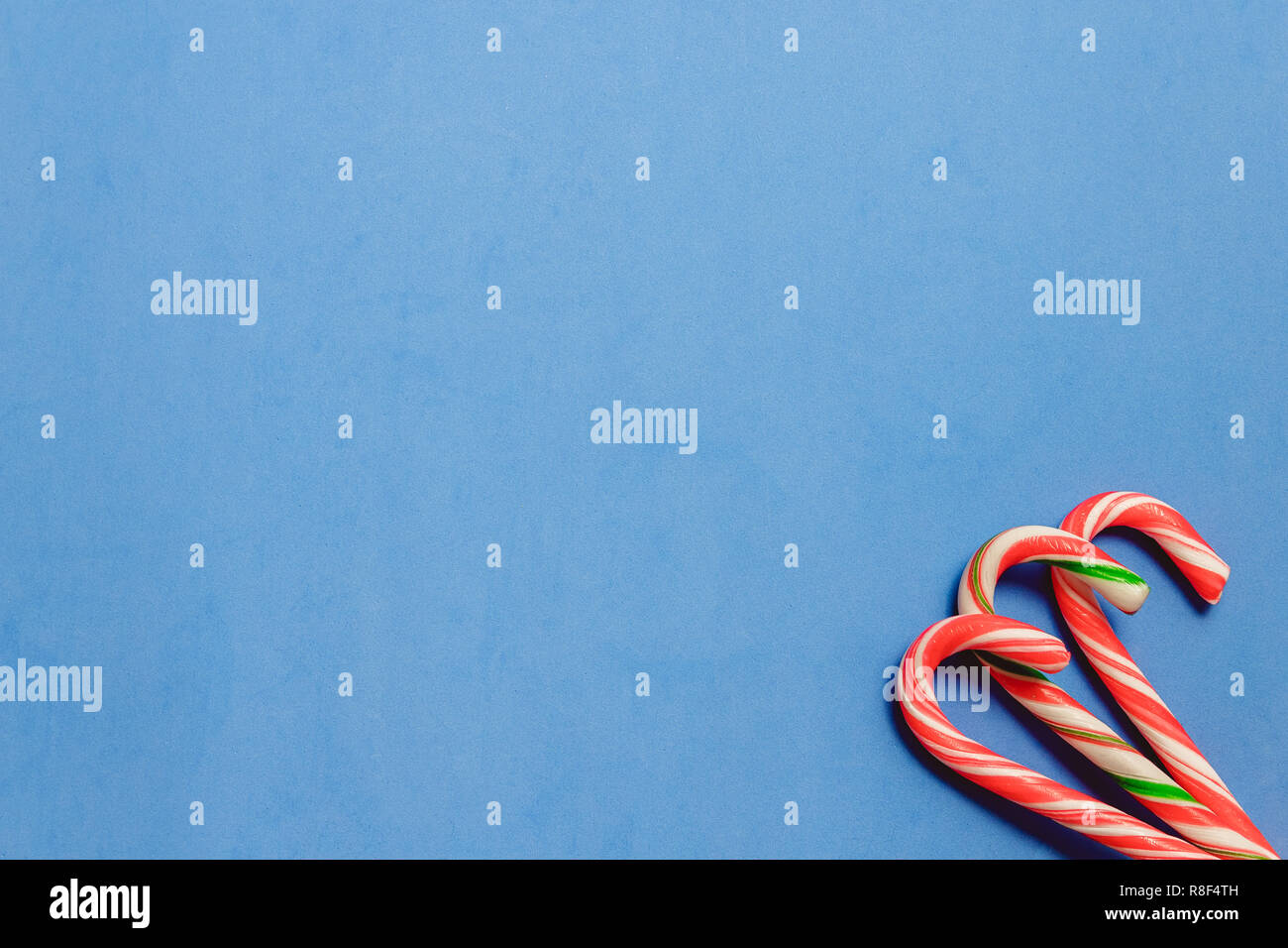 Top view three candy canes on blue background. Stock Photo