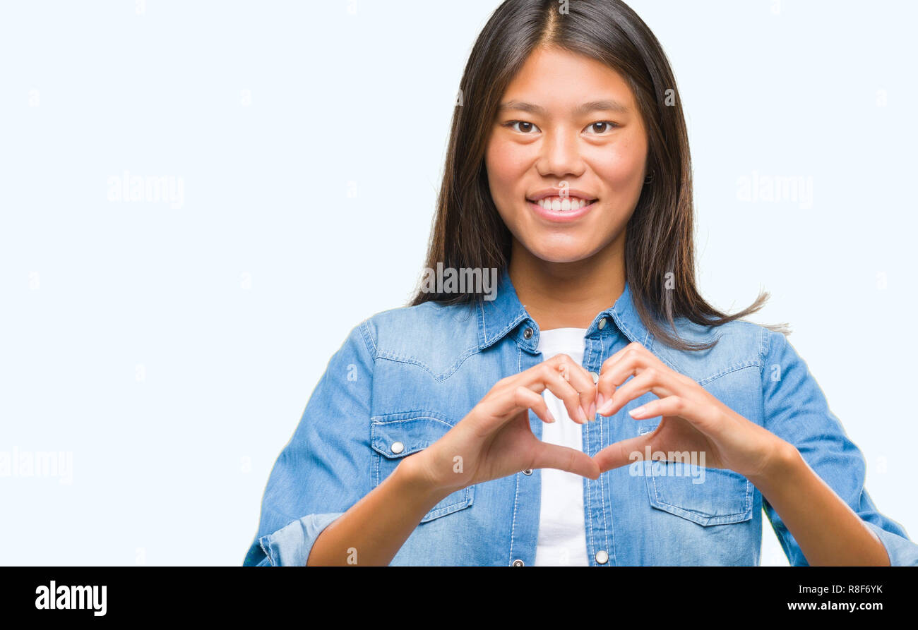 Young asian woman over isolated background smiling in love showing ...