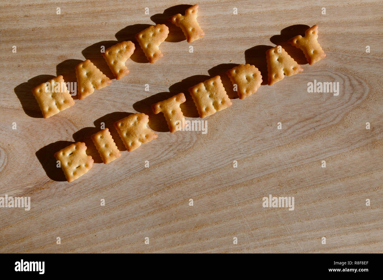 Happy birthday. Text from the salty crackers as printed English letters  that lie on a wooden chopping board. Message, lined with edible letters  Stock Photo - Alamy