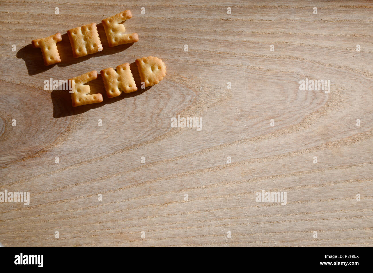 Happy birthday. Text from the salty crackers as printed English letters  that lie on a wooden chopping board. Message, lined with edible letters  Stock Photo - Alamy