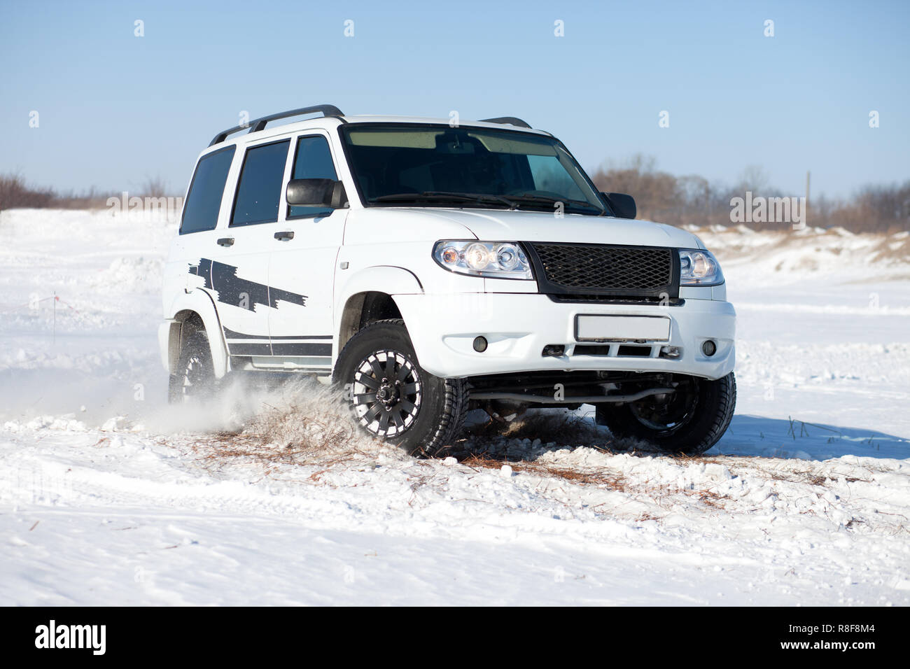 White SUV traveling in the snow Stock Photo