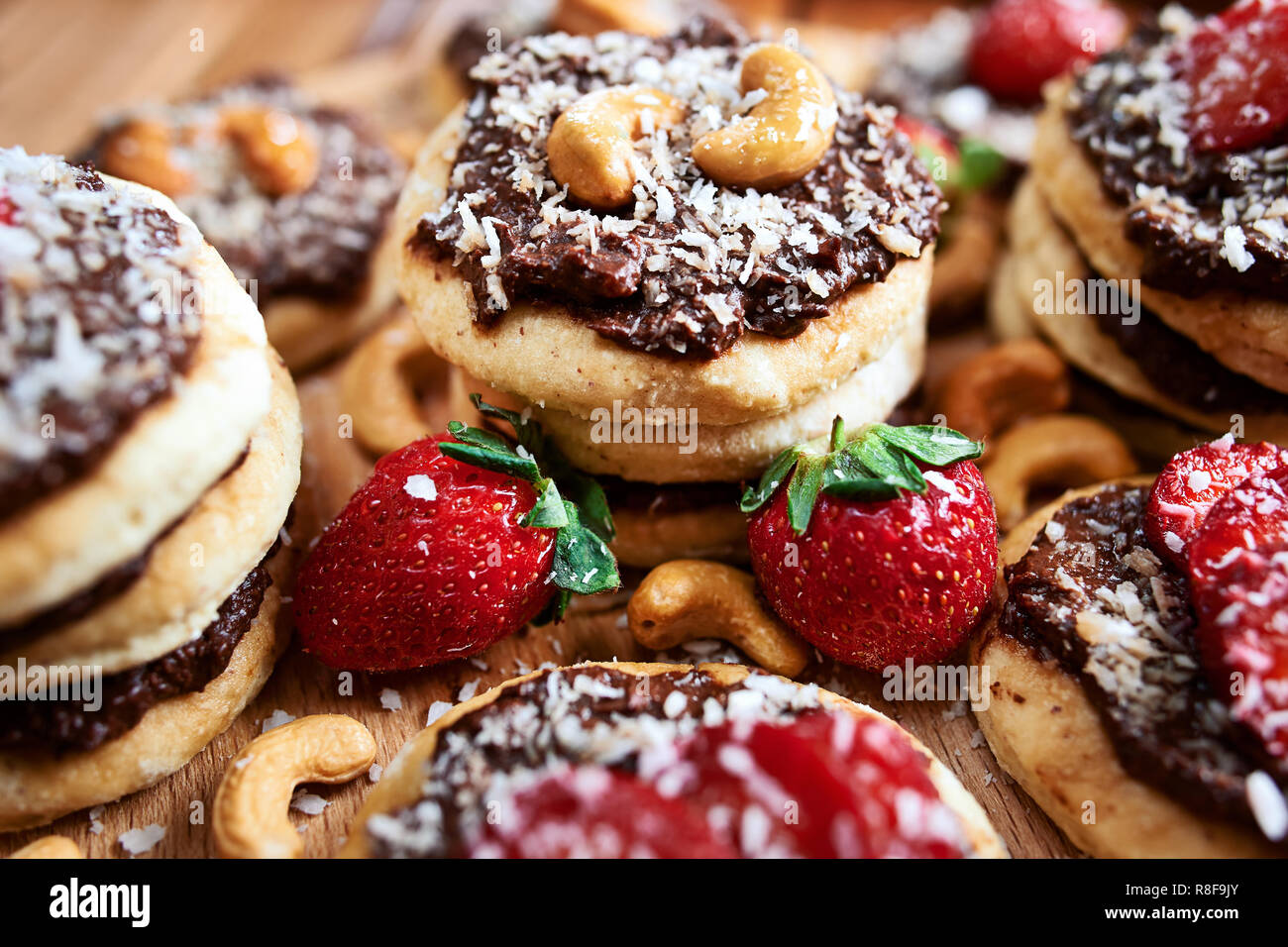 vegan homemade coconut cookies with strawberries and chocolate nut toping, close up Stock Photo