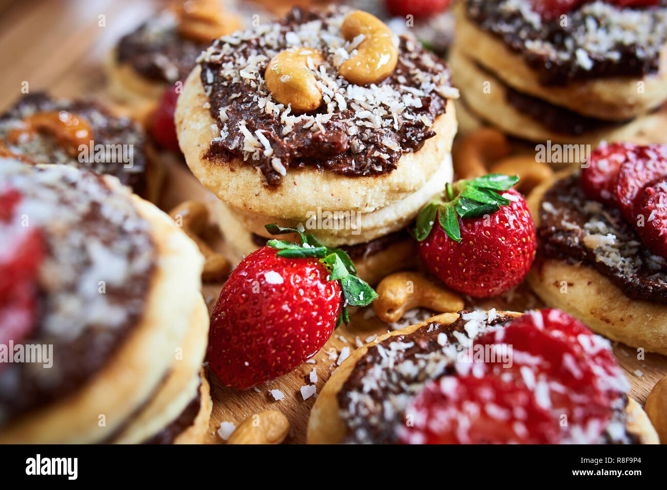 vegan homemade coconut cookies with strawberries and chocolate nut toping, close up Stock Photo