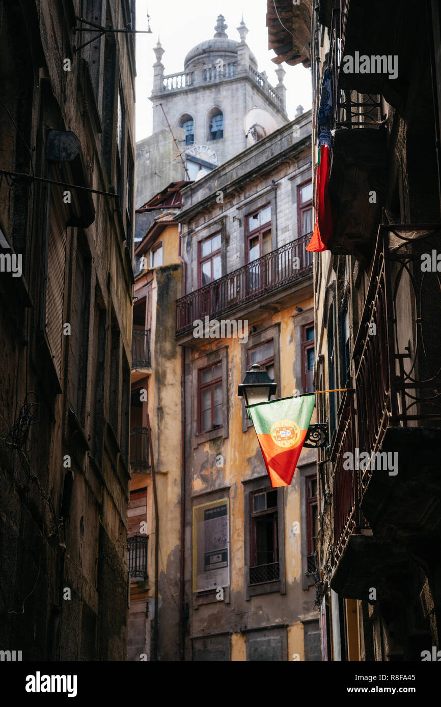 Portuguese flag on narrow cobblestone street leading to Cathedral Se in Porto, Portugal Stock Photo