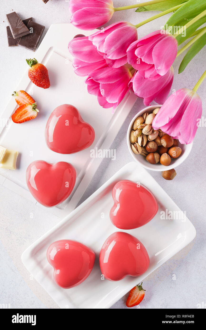 Red heart shaped mousse cakes with berries and chocolate. Stock Photo