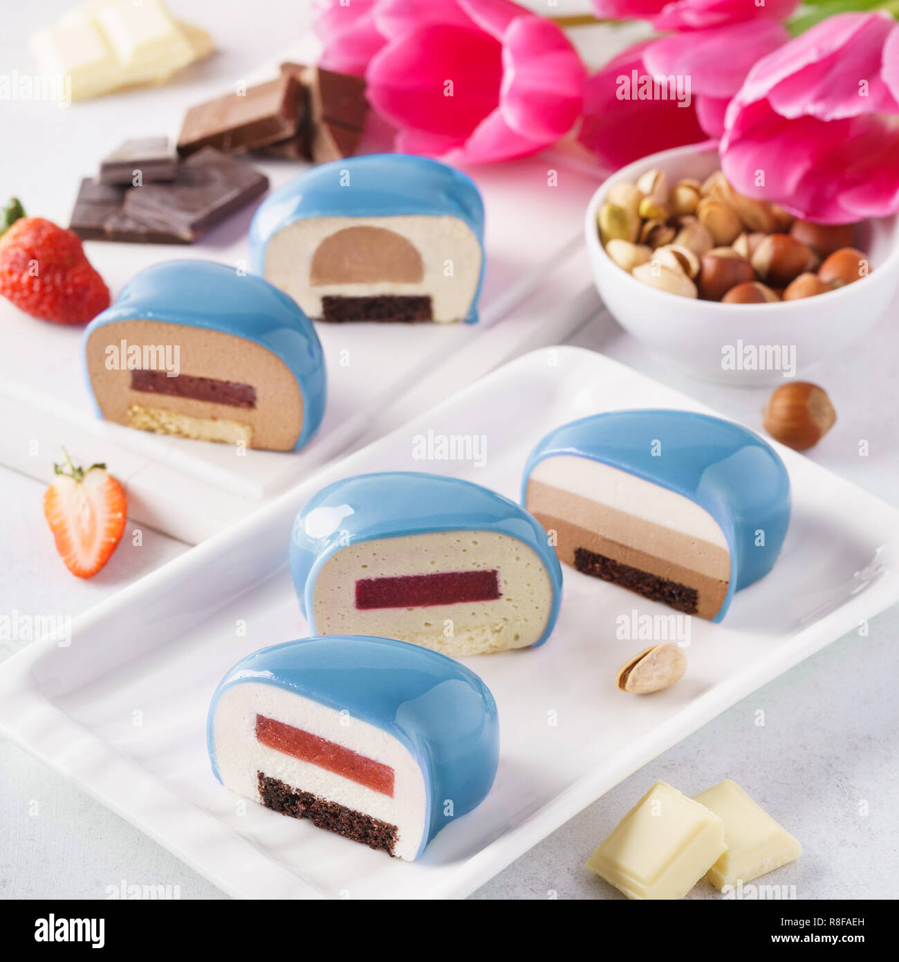 Set of blue heart shaped mousse cakes with various fillings. Stock Photo