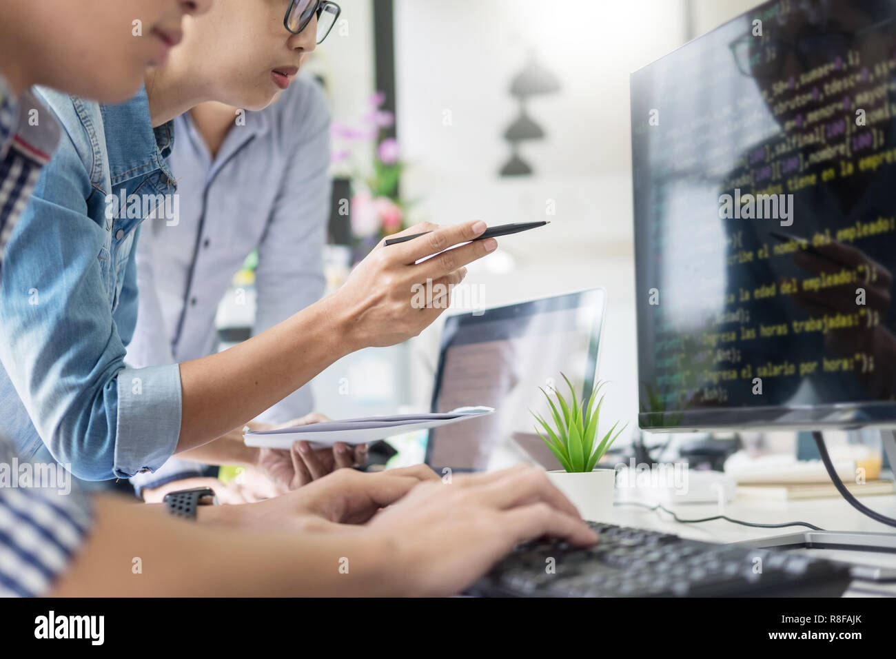 Asian team Outsource Developer Looking Screen Programming Code Working with Laptop Computer Software Stock Photo