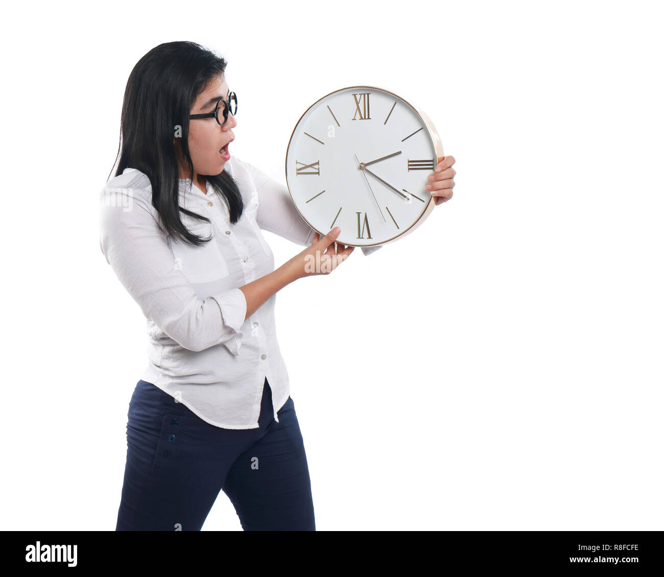Photo image portrait of a beautiful young Asian businesswoman looked shocked while looking time on clock, with both hands holding the clock, half body Stock Photo