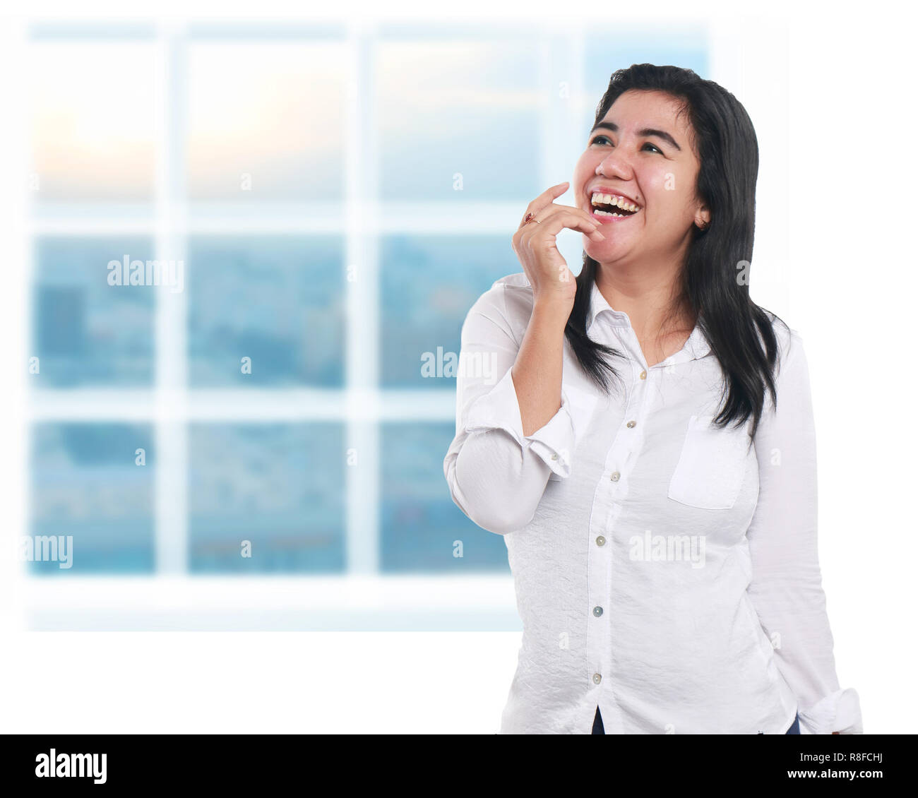 Photo image portrait of a beautiful cute young Asian businesswoman looked very excited and happy, laughing with one hand raised, looking to the side Stock Photo