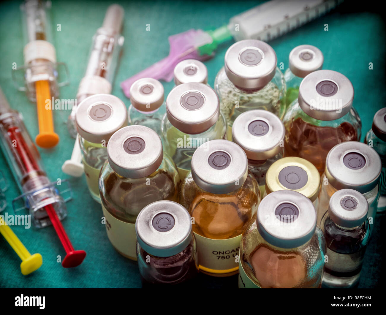 Different types of vials with medication along some syringes in a