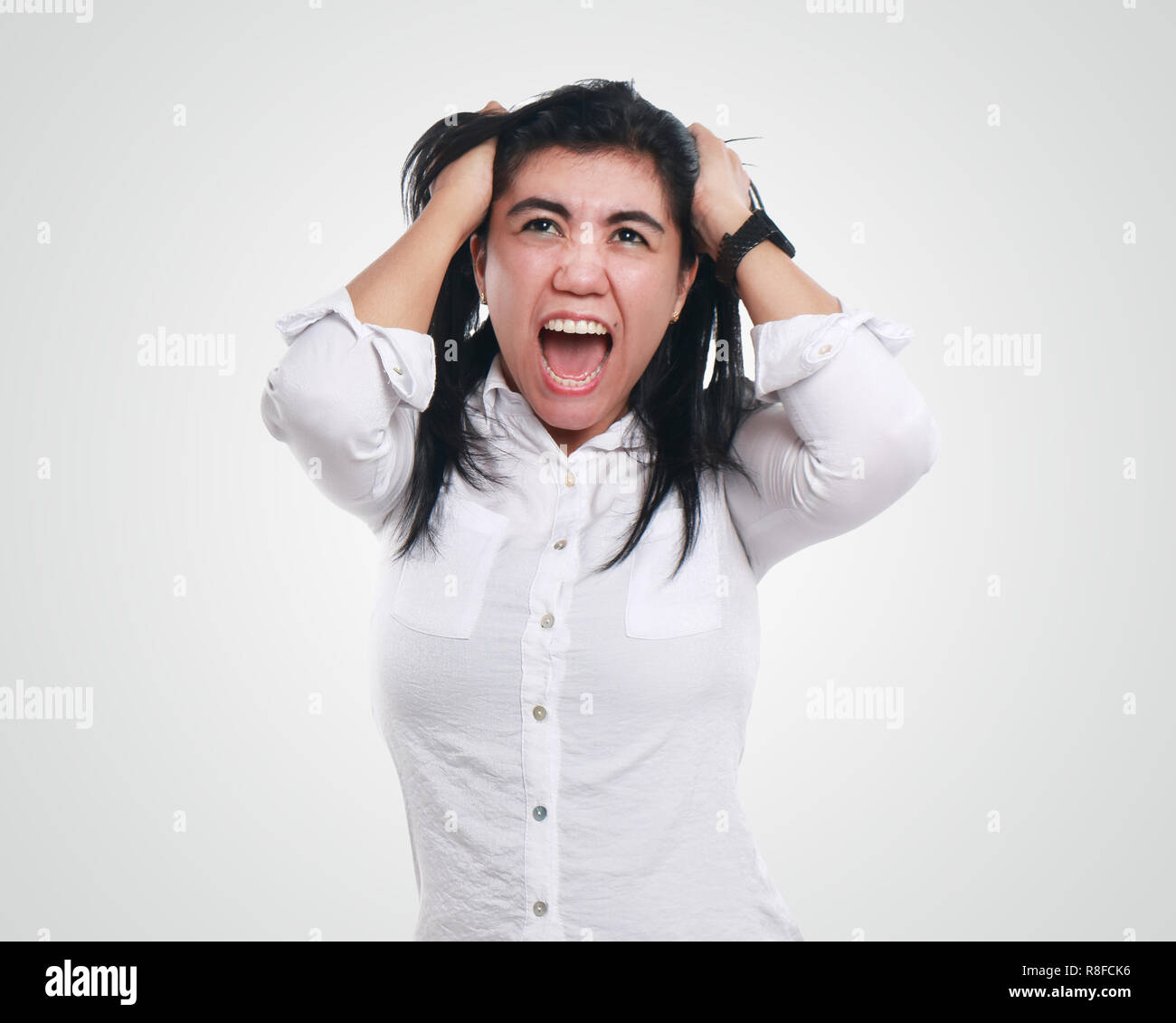 Frustration. Frustrated and stressed young businesswoman screaming. Beautiful young mixed race Asian woman isolated on white background Stock Photo