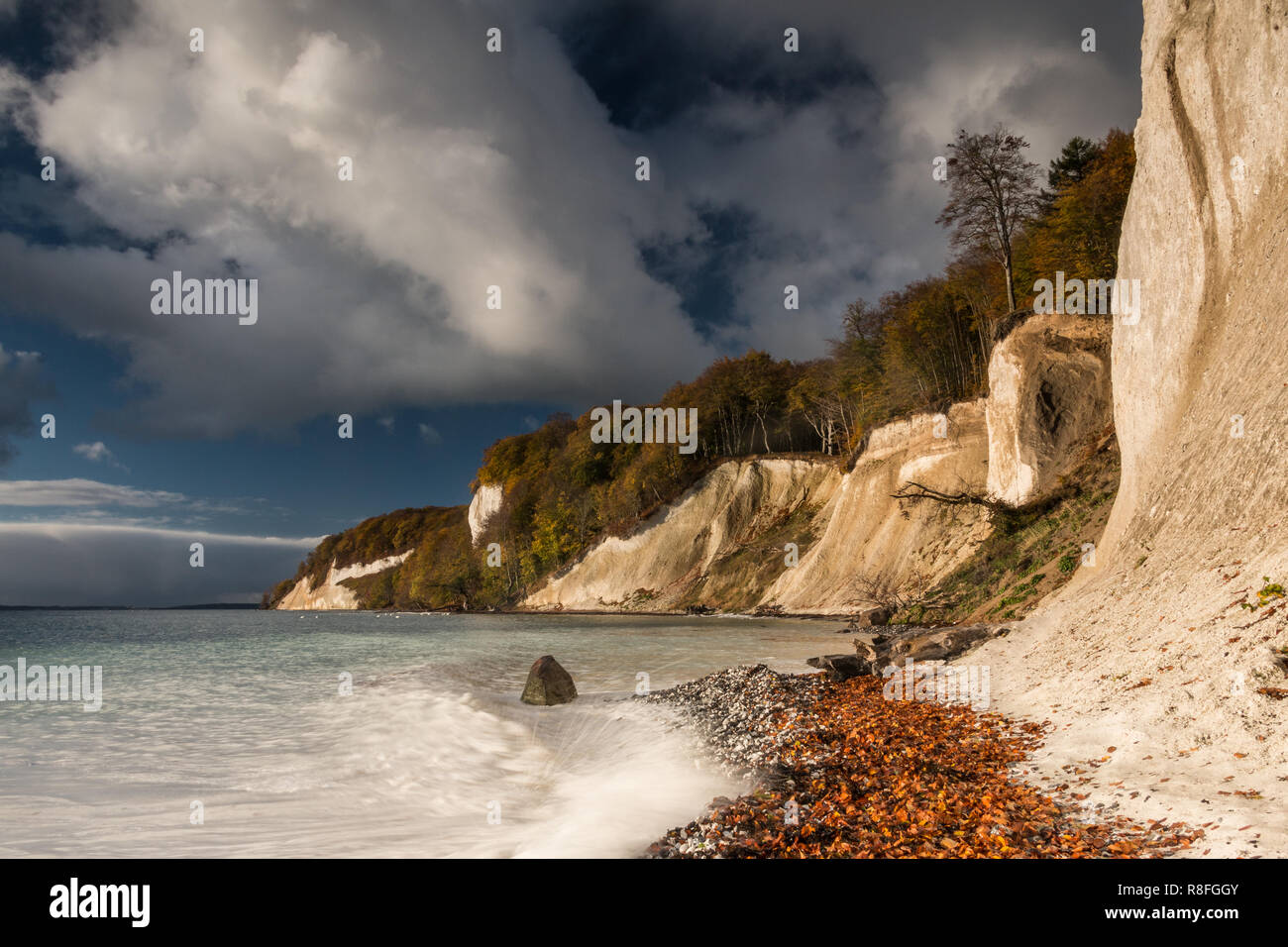 Clouds at blue sky on the Baltic Sea on the island Ruegen. Chalk cliffs at the Jasmund National Park with white water and nature beach Stock Photo