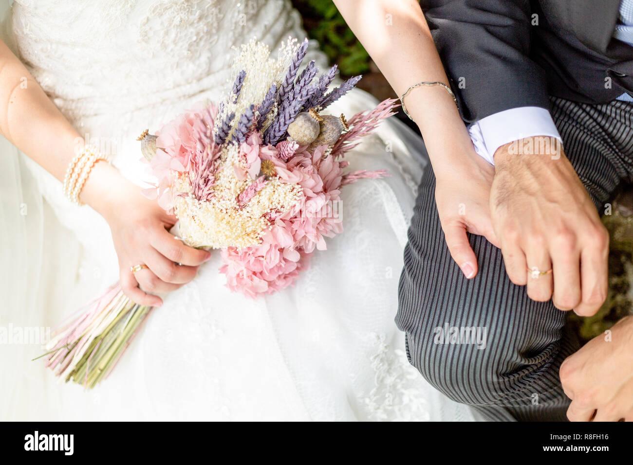 bride and groom holding hands on a park with the bouquet and the ...