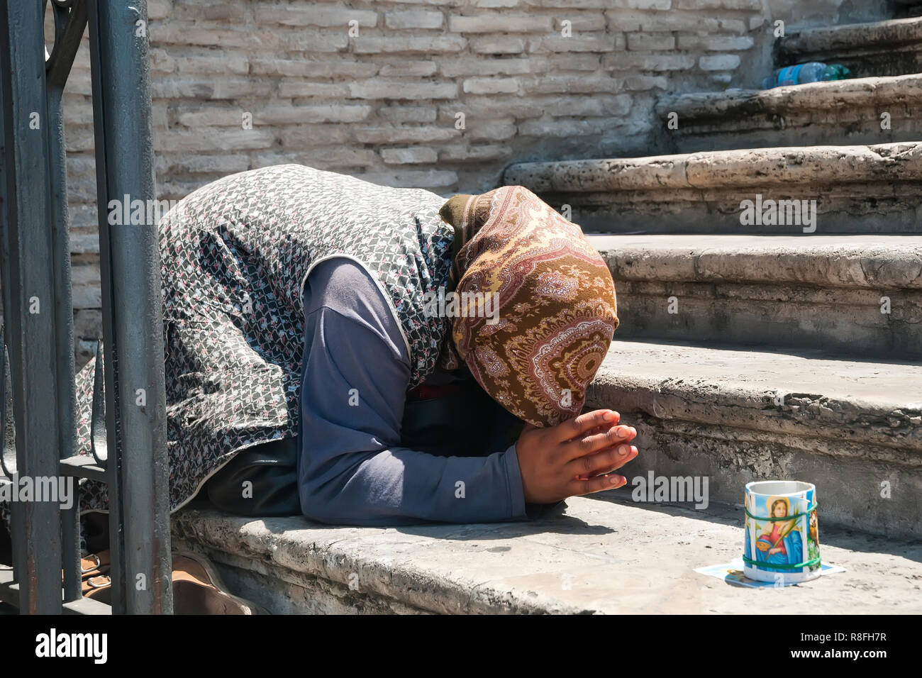 Beggar in Rome - female street beggar in prayer pose Stock Photo