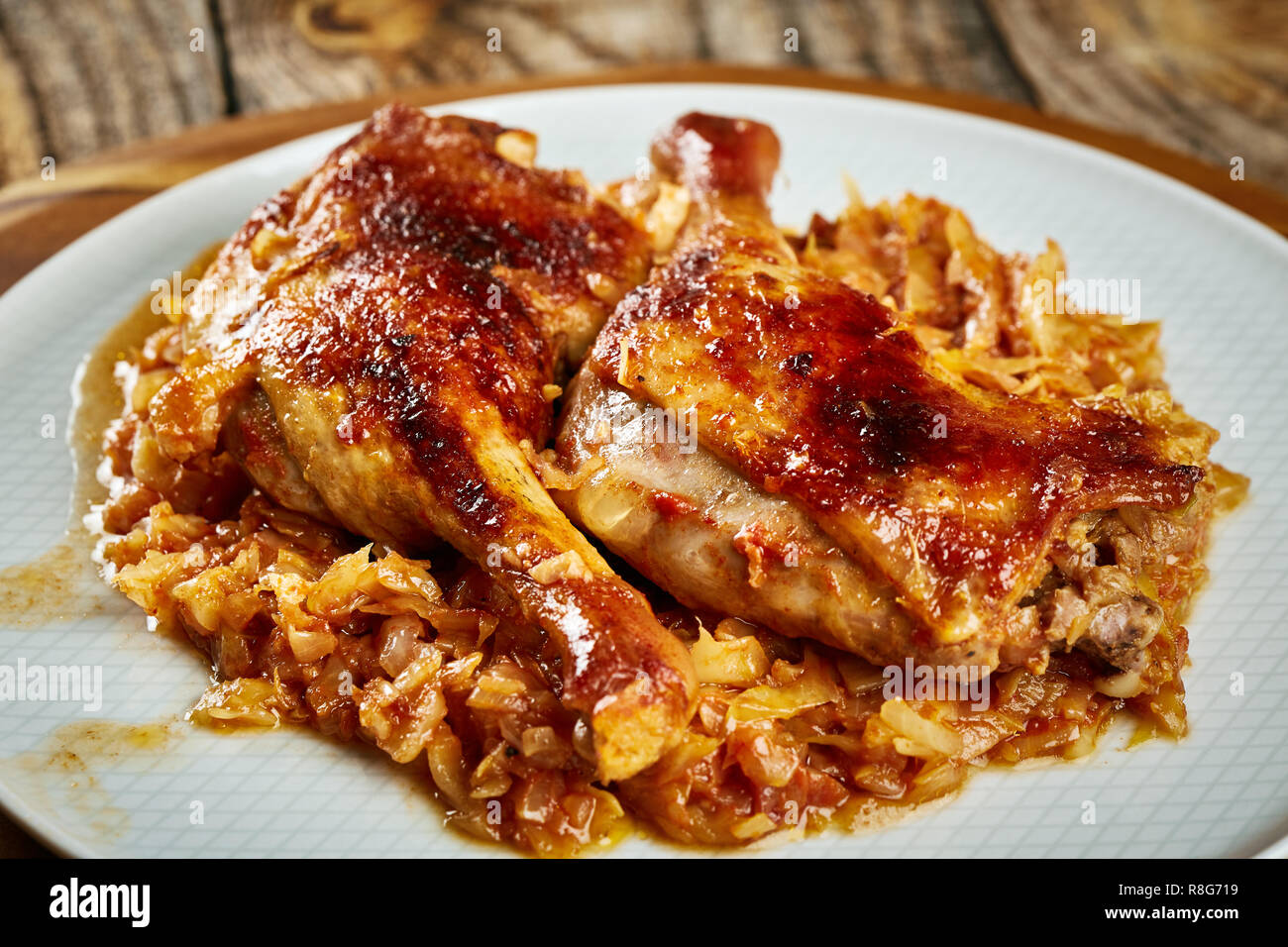 Roasted oven baked duck legs on fresh cabbage caramelized Stock Photo