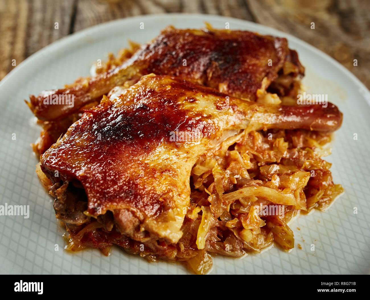 Roasted oven baked duck legs on fresh cabbage caramelized Stock Photo