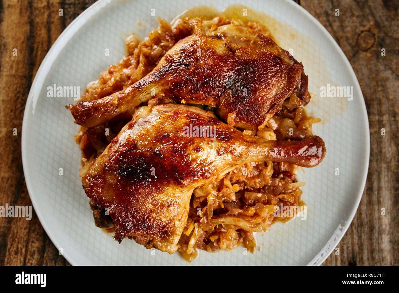 Roasted oven baked duck legs on fresh cabbage caramelized Stock Photo