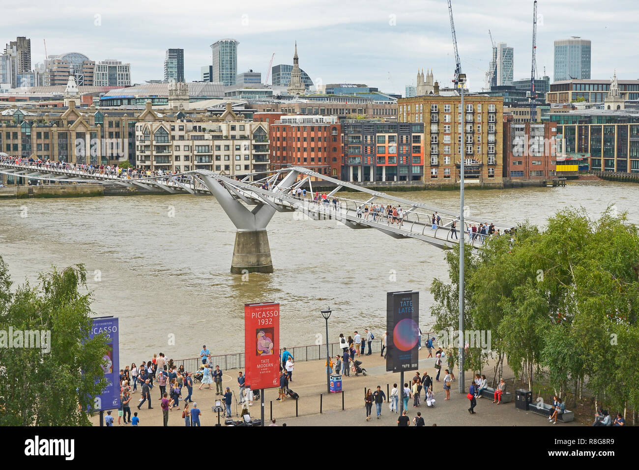 THE MILLENNIUM BRIDGE, THAMES EMBANKMENT, LONDON. AUGUST 2018. The Millennium Footbridge asuspension bridge over the River Thames with the skyline of  Stock Photo