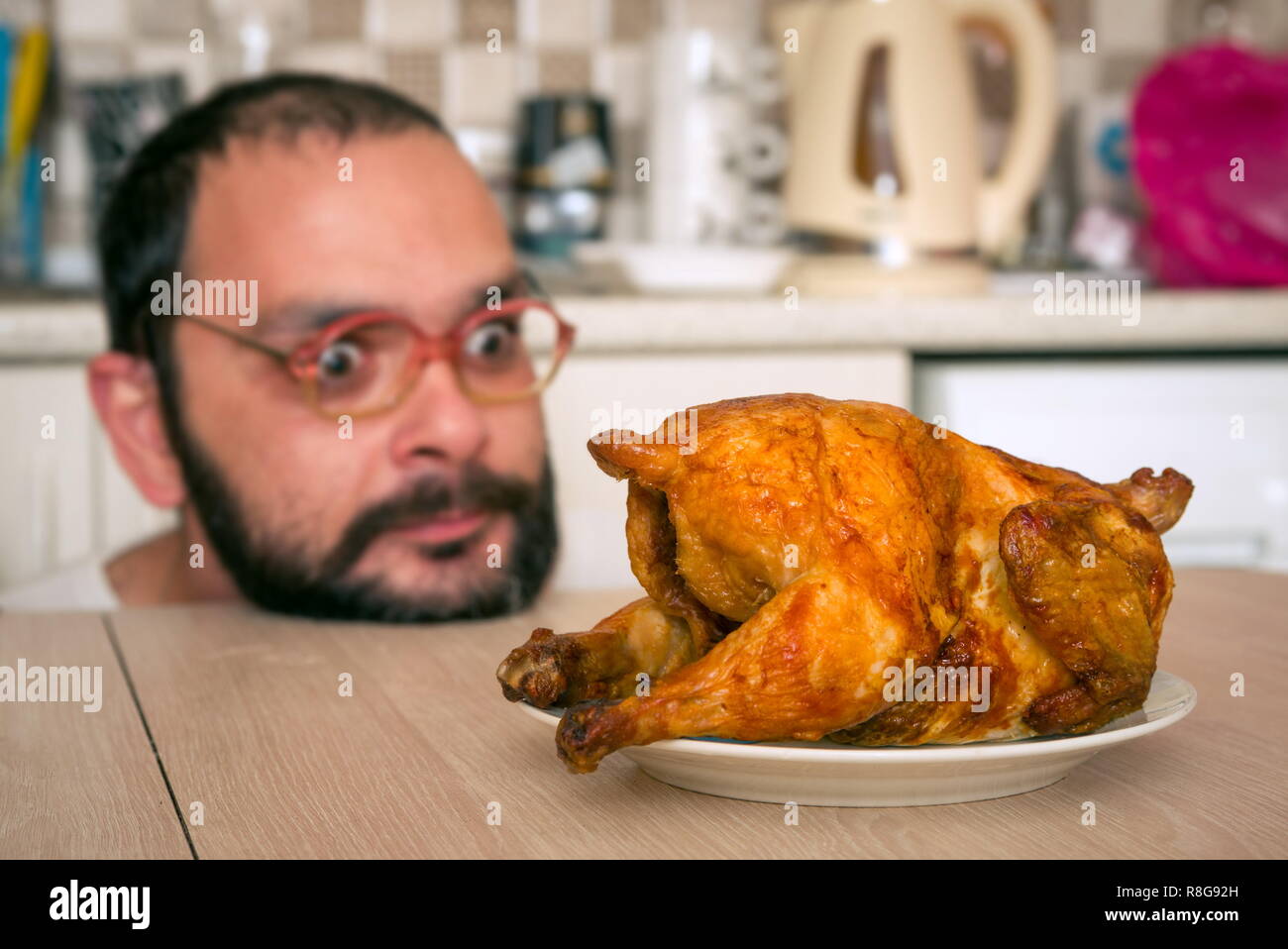 Funny hungry man looking on the chicken Stock Photo - Alamy