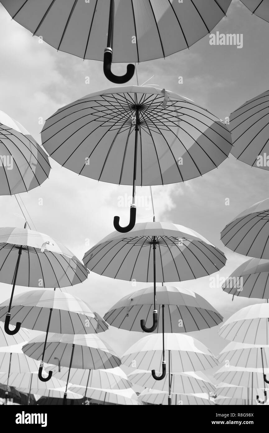 Outdoor art design and decor. Umbrellas float in sky on sunny day. Umbrella sky project installation. Holiday and festival celebration. Shade and protection. Stock Photo