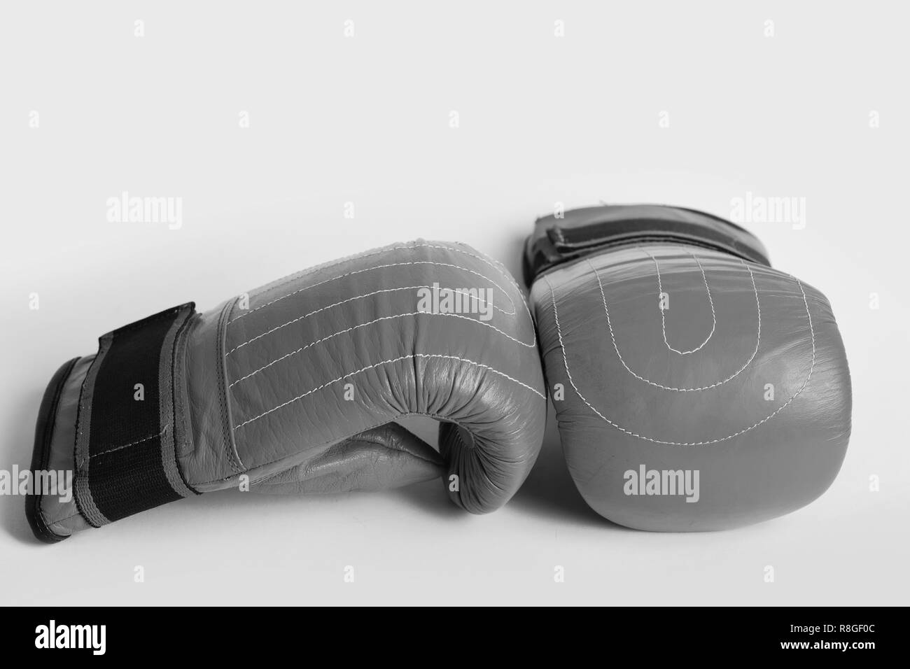 Pair of red boxing gloves for thai wrestling isolated on light lemon yellow background. Concept of gym and active training Stock Photo