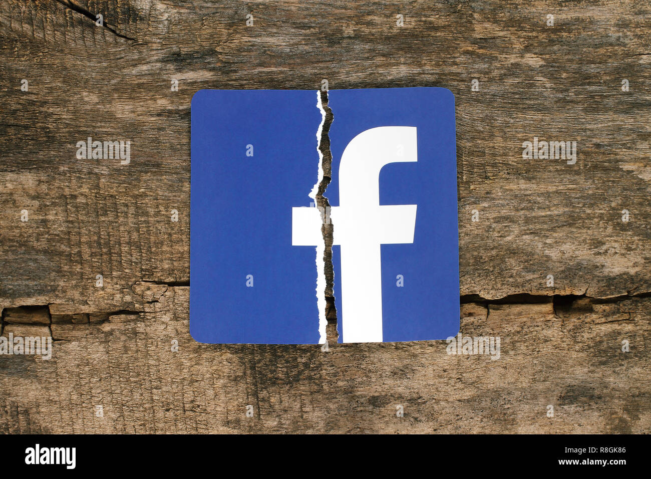 Kiev, Ukraine - November 07, 2018: Facebook icon printed on paper, torn and put on old wooden background. Facebook security and privacy issues concept Stock Photo