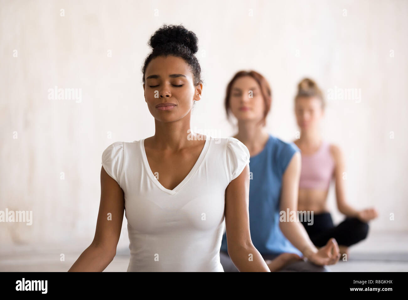 Diverse girls sitting in lotus position doing yoga Stock Photo - Alamy