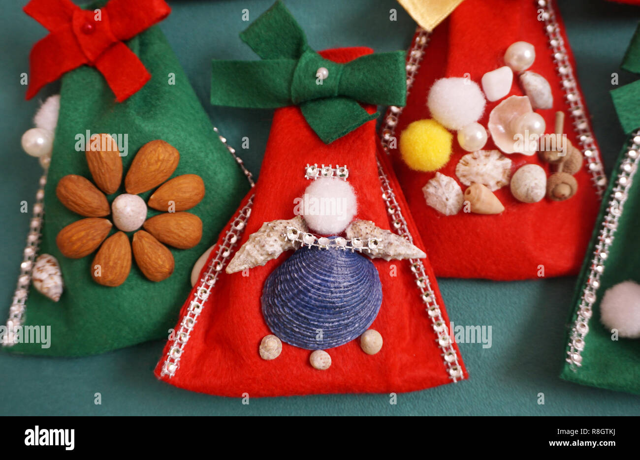 Angel handmade craft, made from seashells, beads, pompons and dried fruit on the felt bag. Christmas craft decoration concept Stock Photo