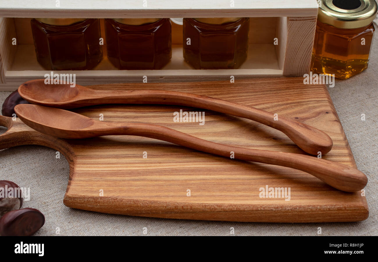 Honey of different varieties in small jars, with wooden kitchen