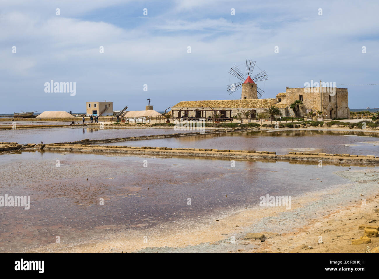 Landscape with saline and windmill at Saline di Trapani e Paceco nature reserve, Sicily, Italy Stock Photo