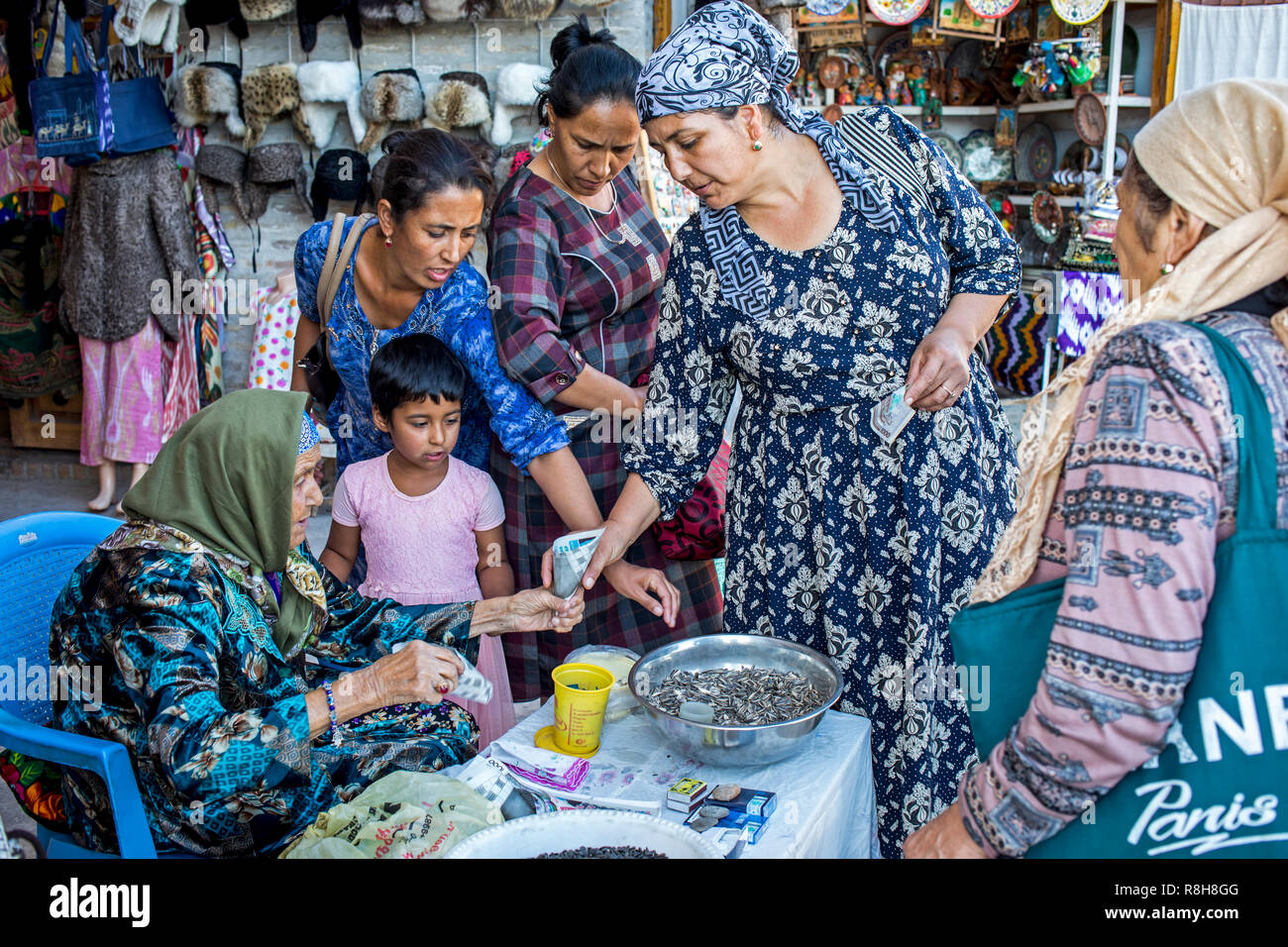 Old woman selling sunflower seeds, in Taki-Telpak Furushon bazaar, Bukhara, Uzbekistan Stock Photo