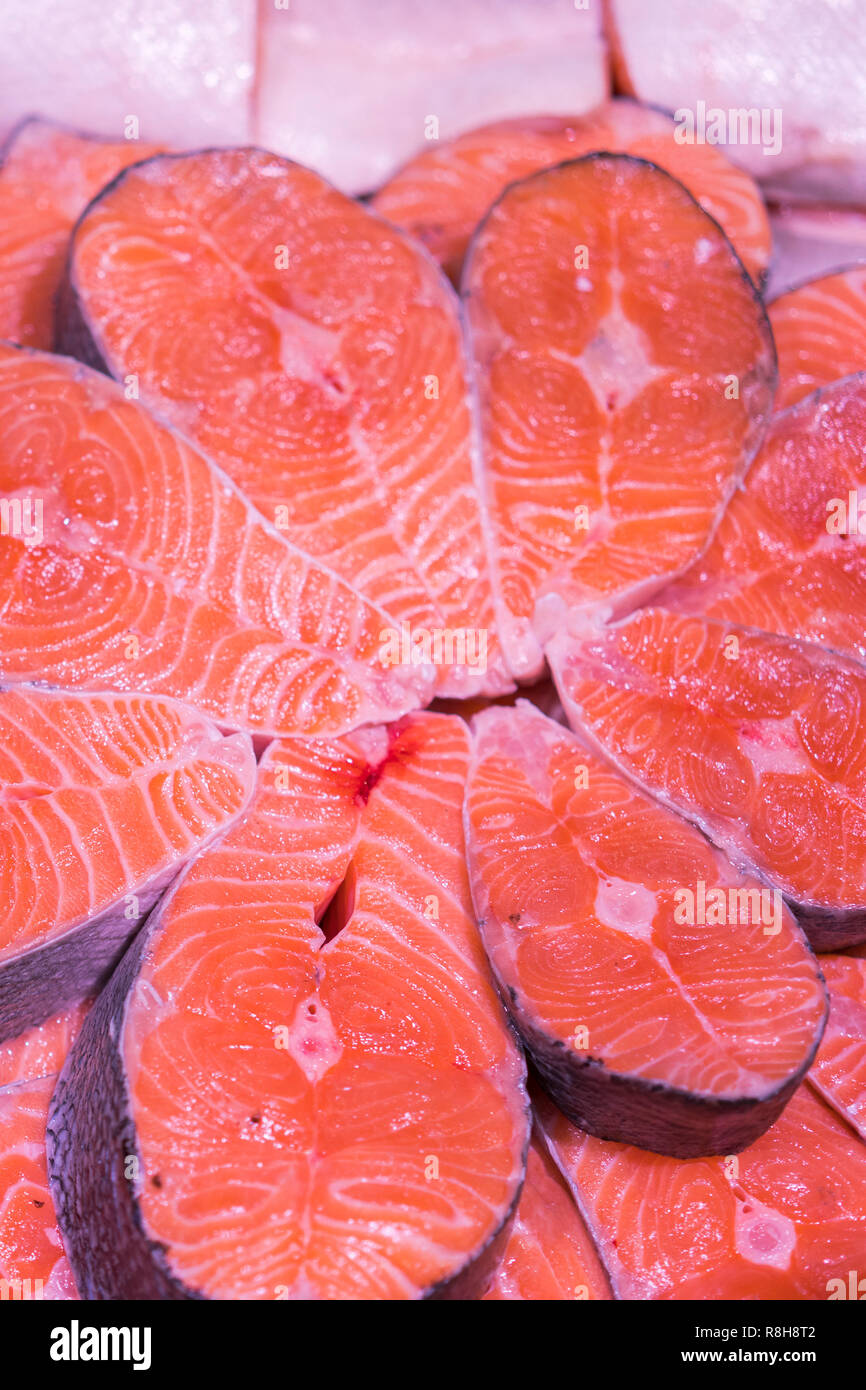Sliced raw, not cooked salmon, red fish, lying in the ice on the ...